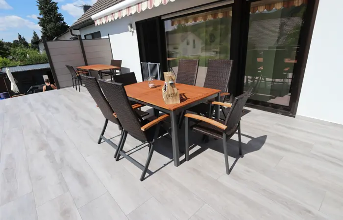 Professionelle Terrassenbau von DMK Bau Reichelsheim - moderne Holzterrasse mit Lounge-Bereich und Sichtschutz.