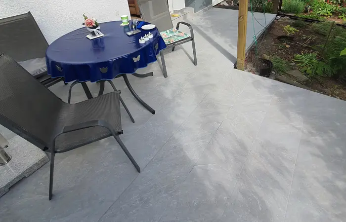 Terrassenlösung von DMK Bau Reichelsheim - moderne Steinterrasse mit Lounge-Möbeln und integrierter Beleuchtung.